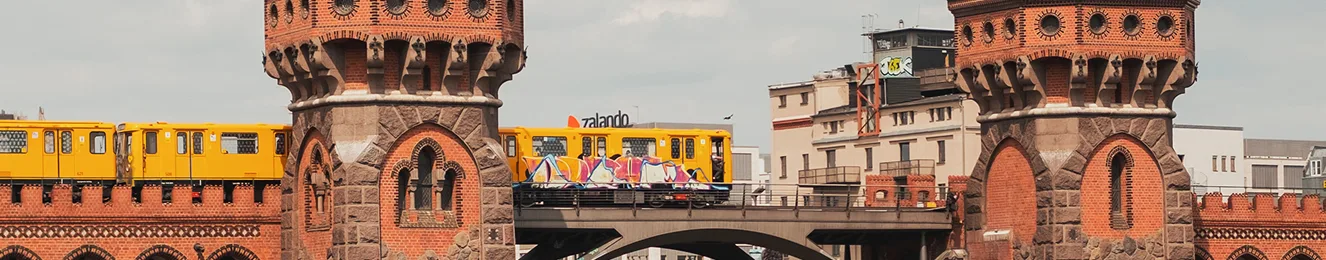 Oberbaumbrücke zwischen Friedrichshain und Kreuzberg in Berlin. Eine gelbe Berliner U-Bahn fährt über die Brücke.